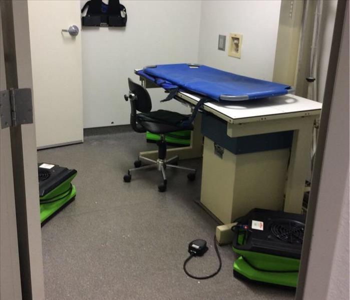 A table, chair, and drying equipment on the floor of a medical office