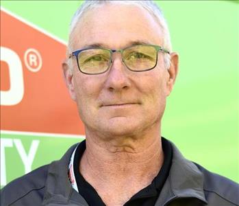 SERVPRO employee standing in front of logo